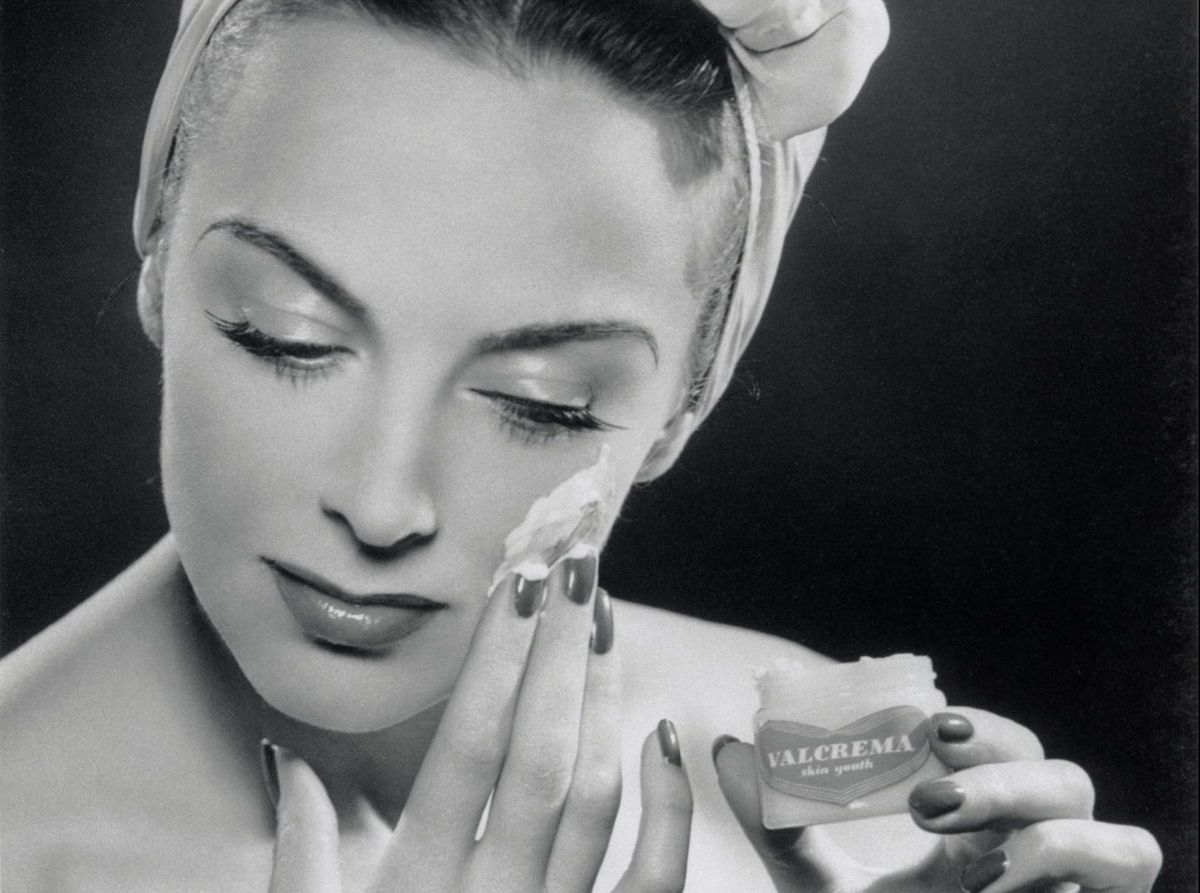 Woman applying skin cream, 1945-1955.