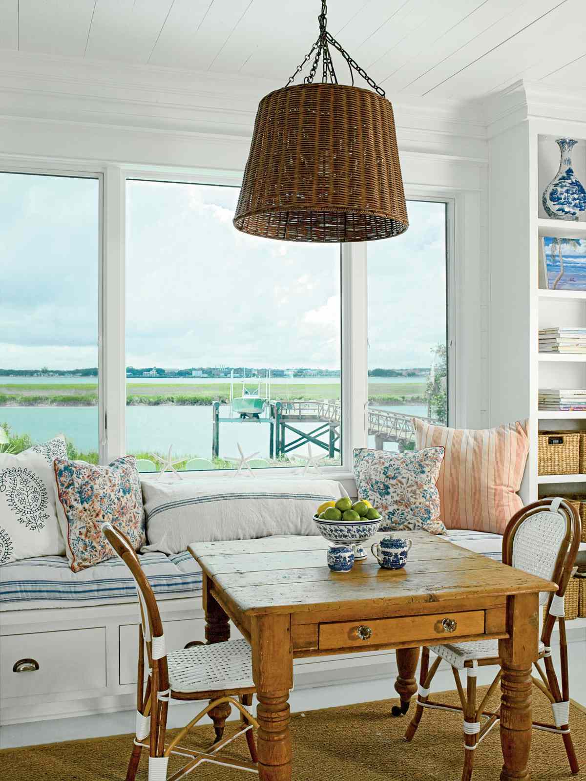 <p>This welcoming breakfast nook has a built-in bench with cabinets underneath for extra storage. Pile it high with pillows for a snug spot to watch the water. The woven hanging lamp and pretty patterns offer texture and interest to this small space.</p>
                            