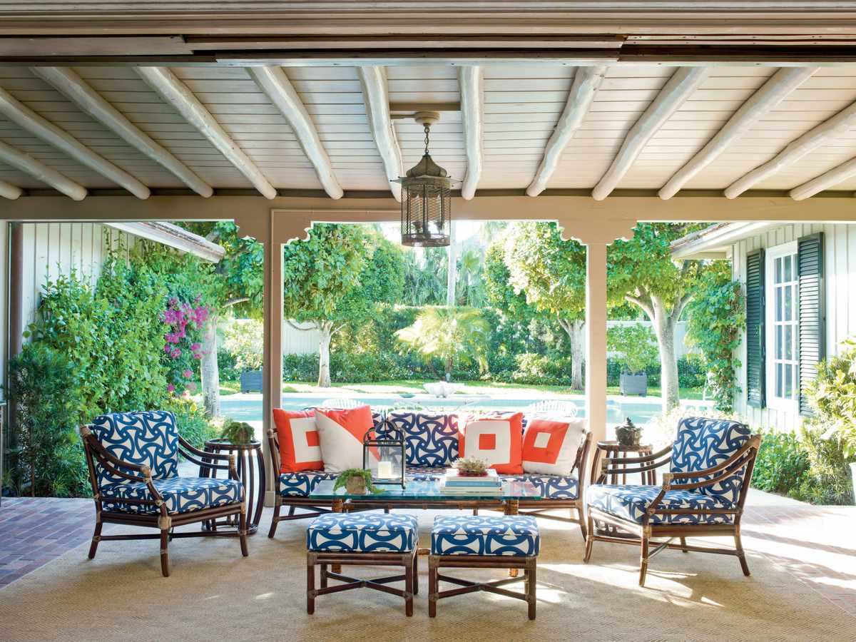<p>Deep navy and pops of bright orange create an inviting outdoor atmosphere.  Vintage bamboo furniture gets revived with cushions covered in a geometric print.</p>
                            