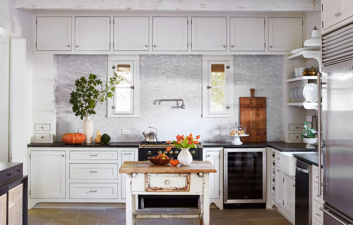 White Kitchen with Marble Backsplash and Vintage Table Island