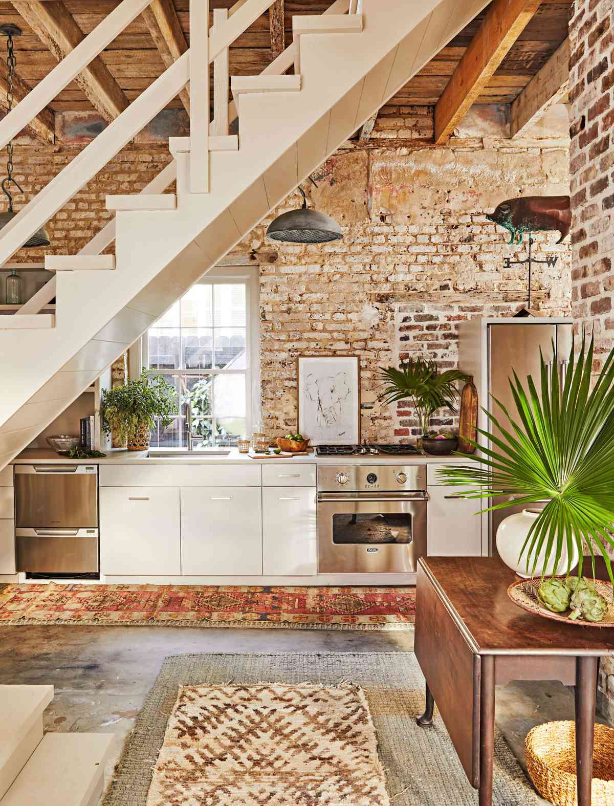 Brick walled carriage house kitchenette under the stairs