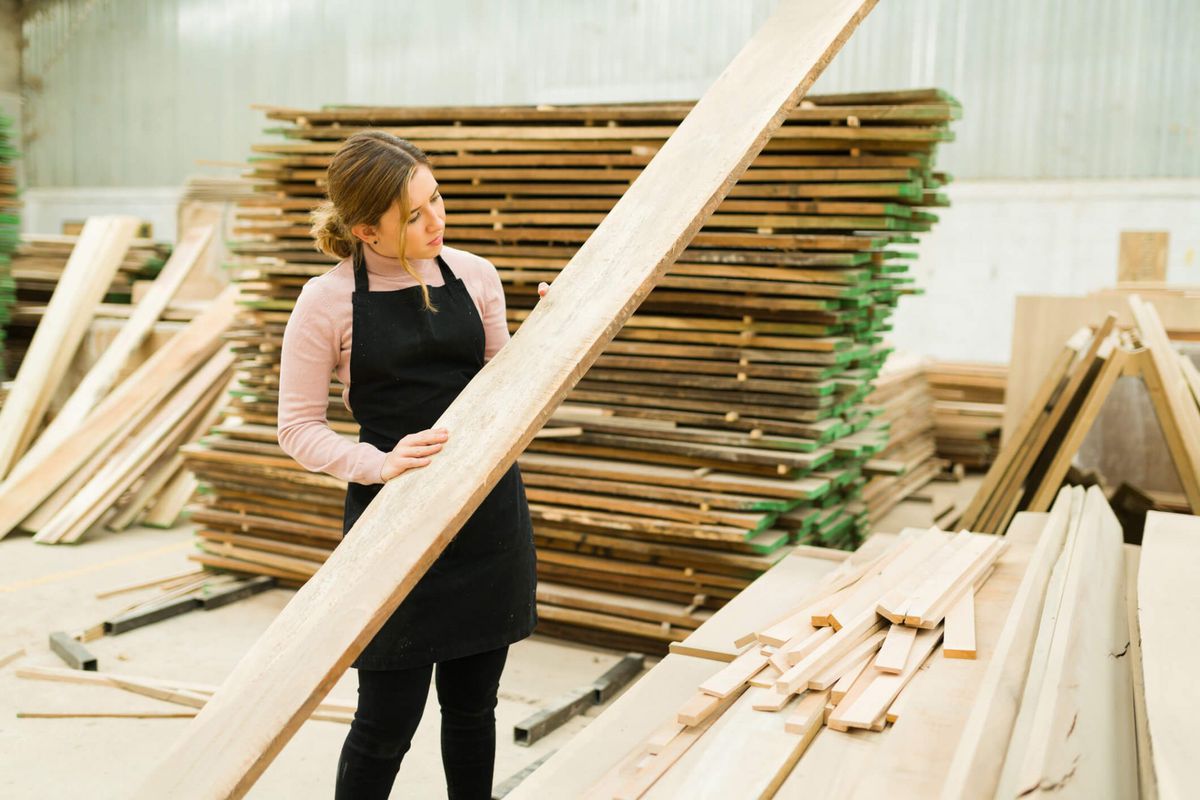 woman holding lumber/wood plank