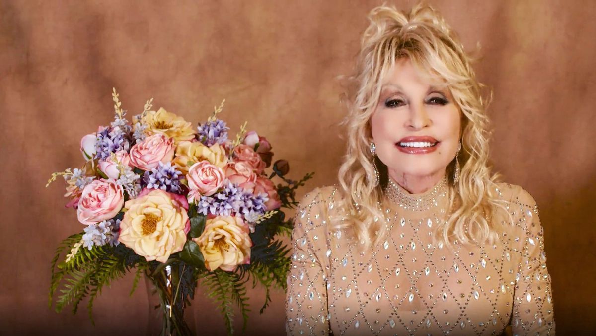 Dolly Parton Next to Floral Arrangement