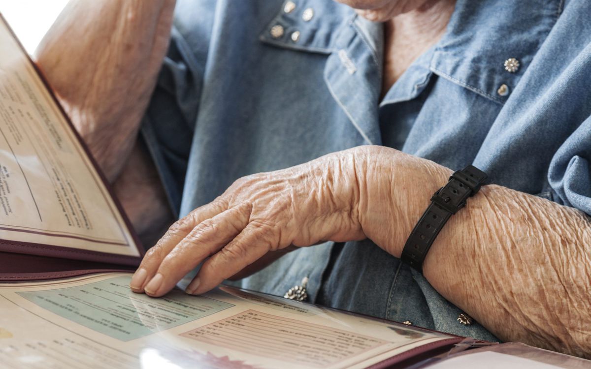 Elderly woman touching and reading restaurant menu