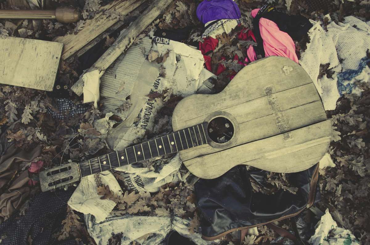 Close-Up Of Broken Guitar In Garbage Outdoors