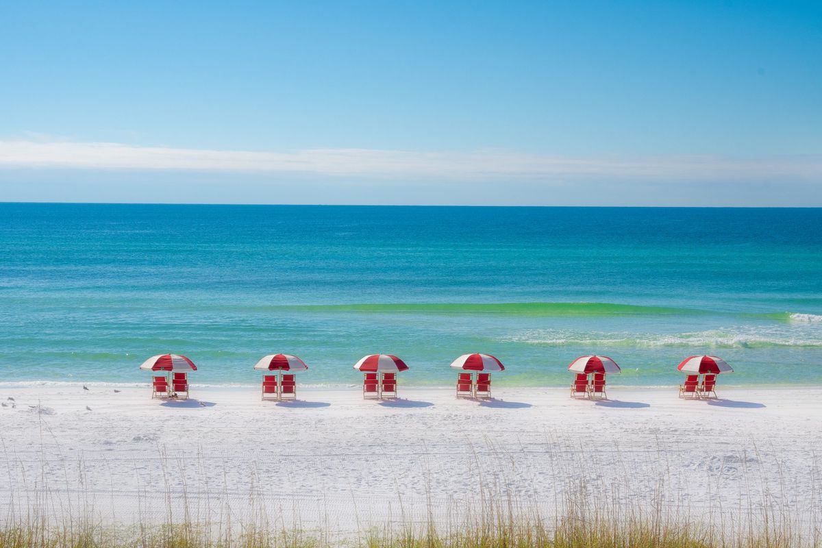 Colorful Row of Red Chairs on the Beach