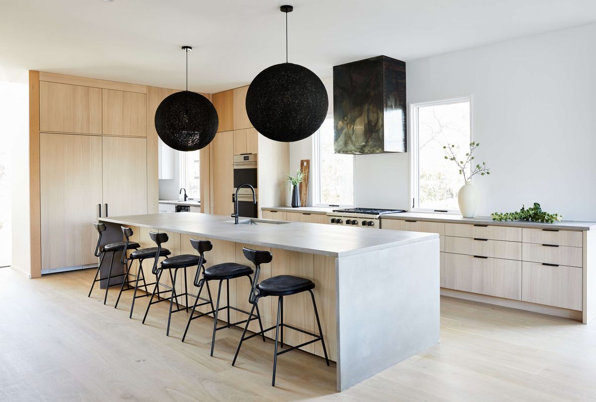 white kitchen with black pendant lights and bar stools