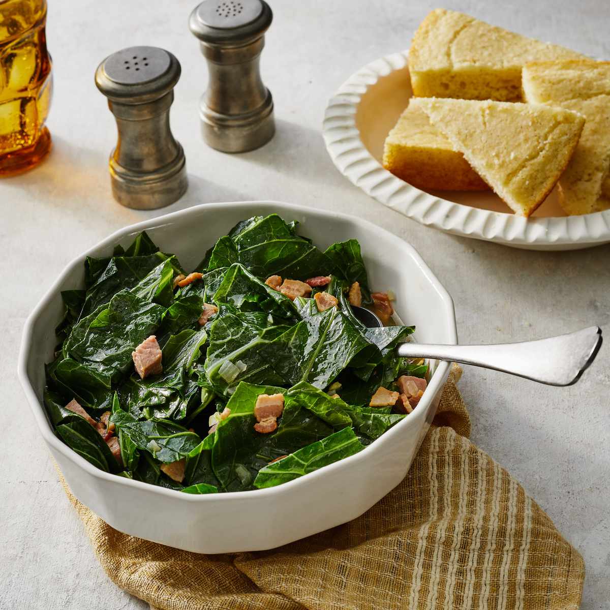Southern-Style Collard Greens in a white bowl with a bowl of cornbread beside it