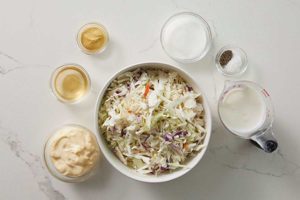 ingredients for coleslaw on a white marble surface