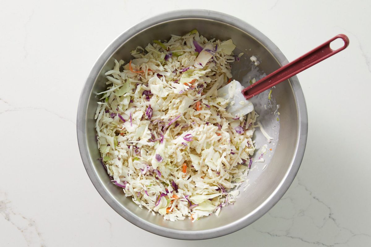 stirring coleslaw into dressing