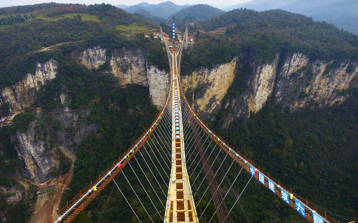 ZHANGJIAJIE, CHINA - DECEMBER 03:  (CHINA OUT) Aerial view of the glass-bottom bridge with steel beams completed at Tianmenshan National Forest Park on December 3, 2015 in Zhangjiajie, Hunan Province of China. World's longest glass-bottom bridge between t