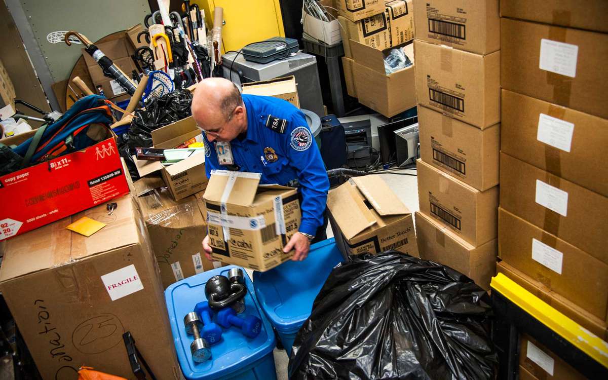 TSA officer Igor Markasyan starts to empty the storage facility at Newark Liberty International Airport
