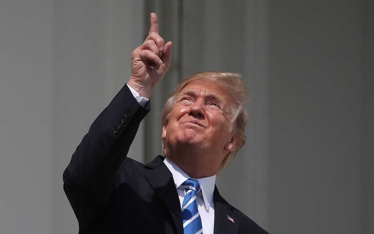 U.S. President Donald Trump looks up toward the Solar Eclipse on the Truman Balcony at the White House on August 21, 2017 in Washington, DC.