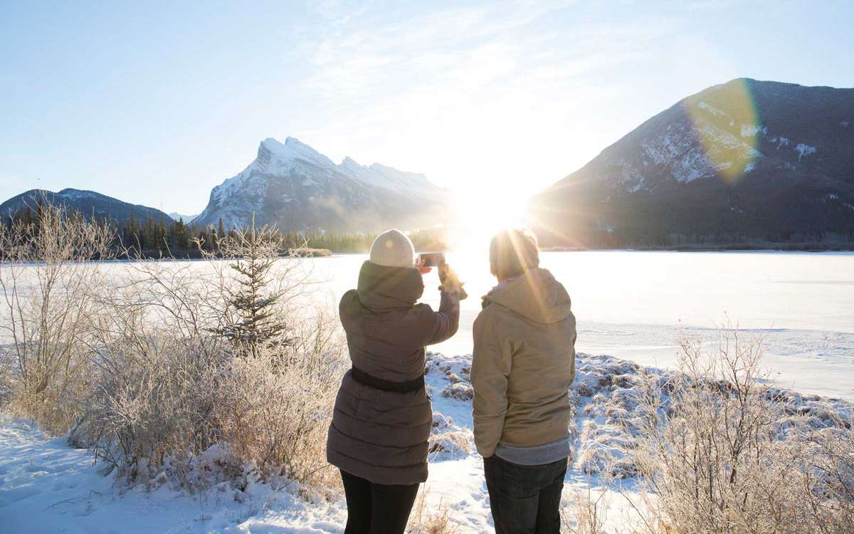 People taking a photo of a frozen lake in the winter