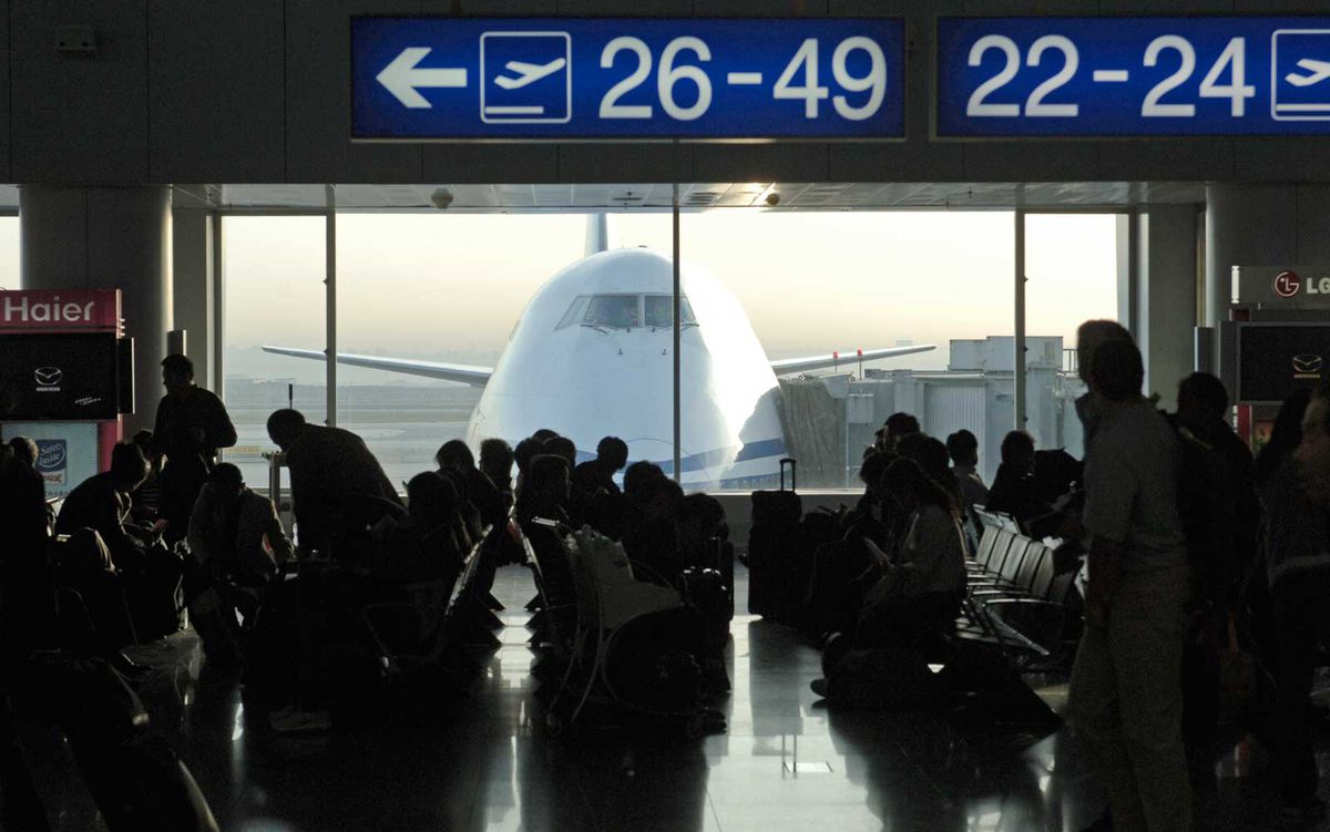 Passengers wait at airport gate terminal