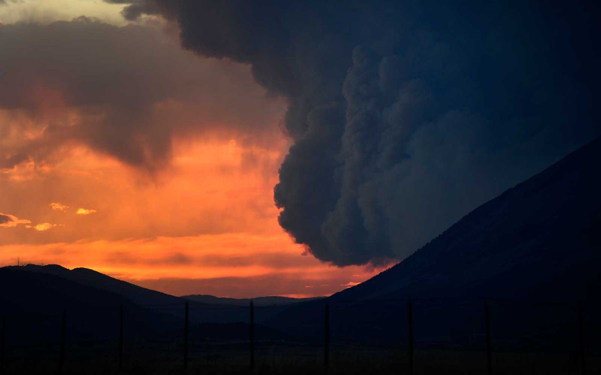 The large plume of the Spring Creek Fire is lit up by the setting sun  on July 4, 2018 in La Veta, Colorado.