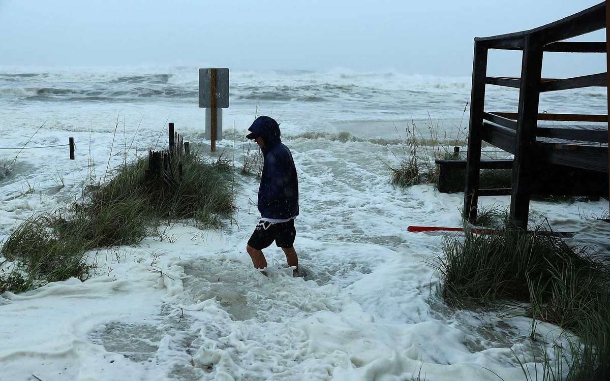 PANAMA CITY BEACH, FL - OCTOBER 10:  Cameron Sadowski walks along where waves are crashing onto the beach as the outer bands of  hurricane Michael arrive on October 10, 2018
