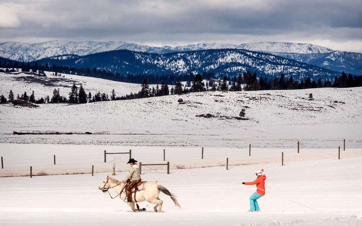 Skijoring (where a skier is pulled behind a horse) at Paws Up luxury guest ranch in Montana