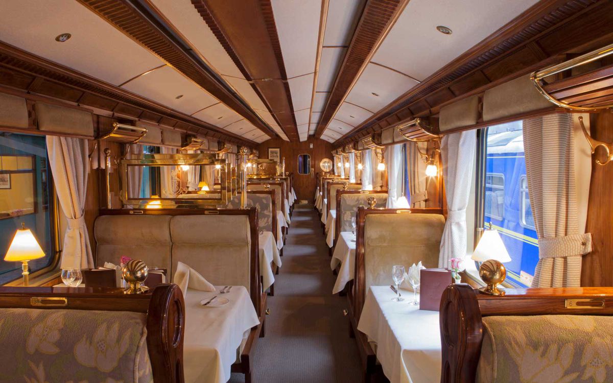 The dining car with tables set for dinner on the Orient-Express Hiram Bingham train which runs between Cusco (Poroy) and Machu Picchu via Ollantaytambo