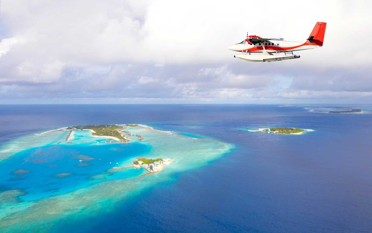 Sea plane flying above Maldives islands, Raa Atoll