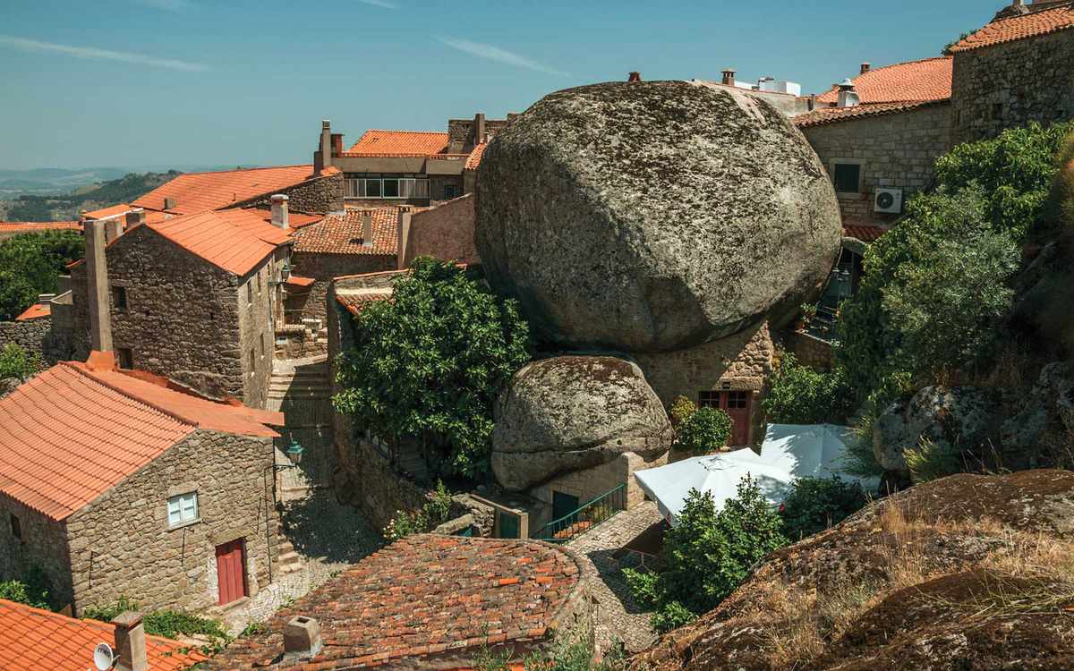 Rooftops of old stone houses with rocks and alley among them in a sunny day at Monsanto.