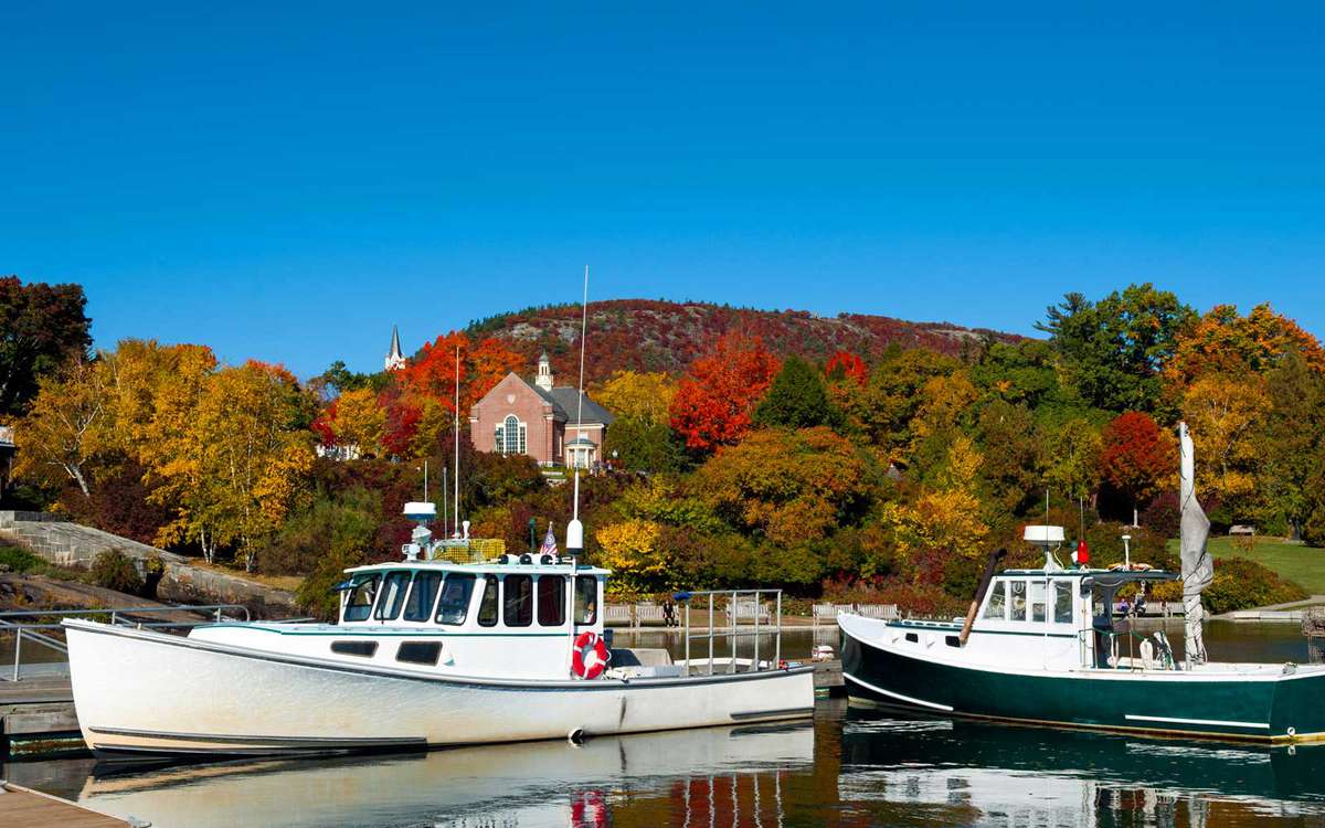 Lobster boats in Camden, Maine Harbor with fall foliage