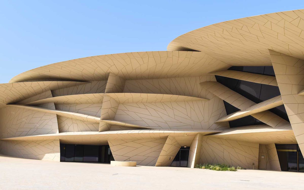 Exterior of the new National Museum of Qatar building, on a clear summer day.