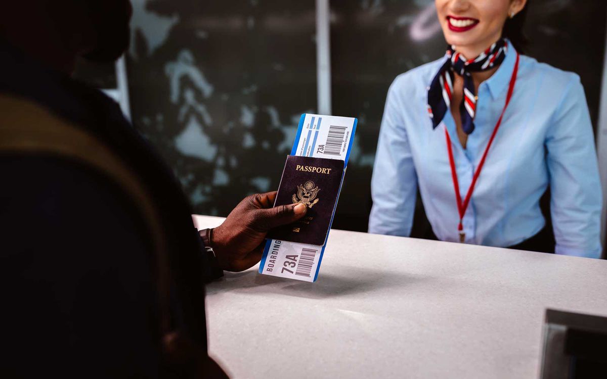 Traveler holding passport and boarding pass at airport check-in counter