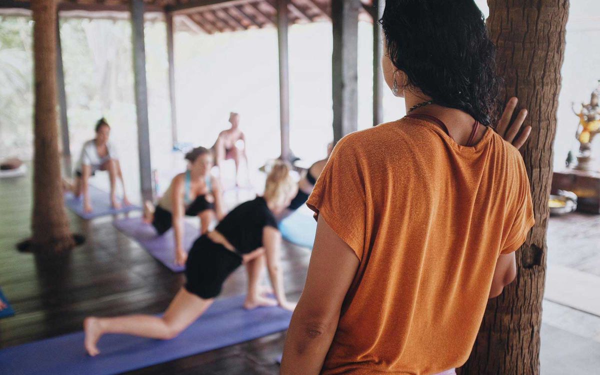 Yoga teacher watching her class at Ashiyana Yoga school in Goa, India
