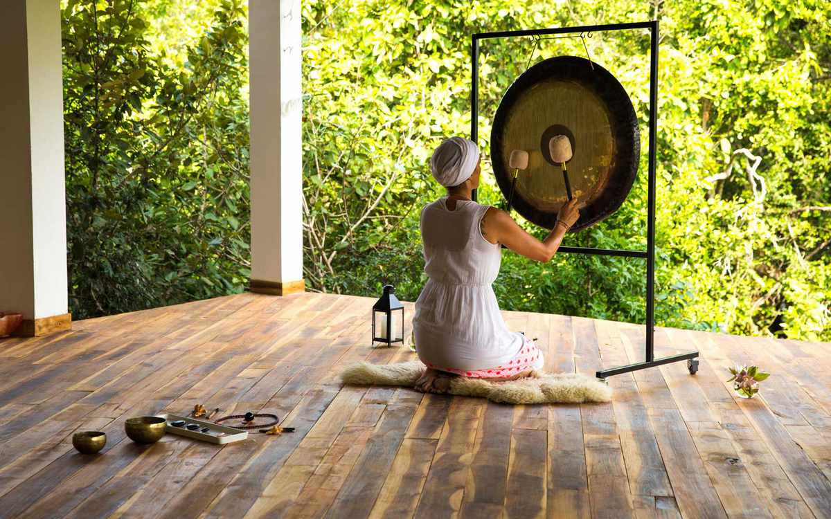 Woman playing a gong at the Sen Wellness retreat in Sri Lanka