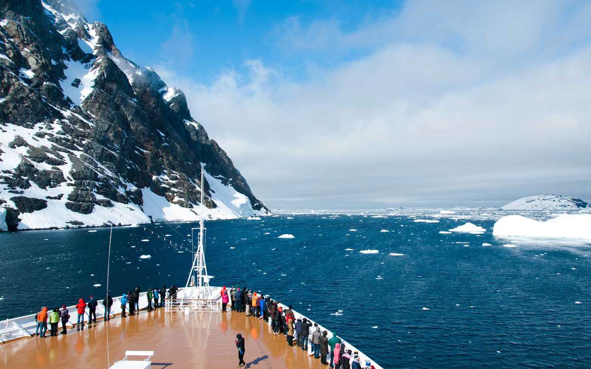 Mountains and cruise ship in Antarctica in sunny day