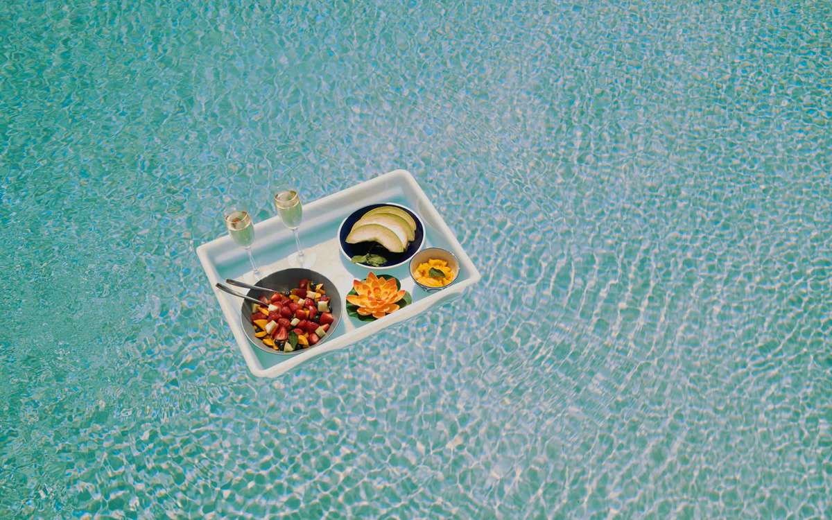 A Breakfast tray floats across a pool