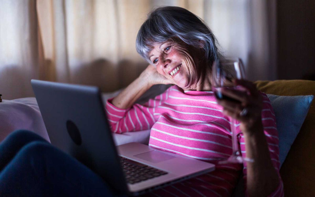 Senior woman using laptop computer to speak to friends from home