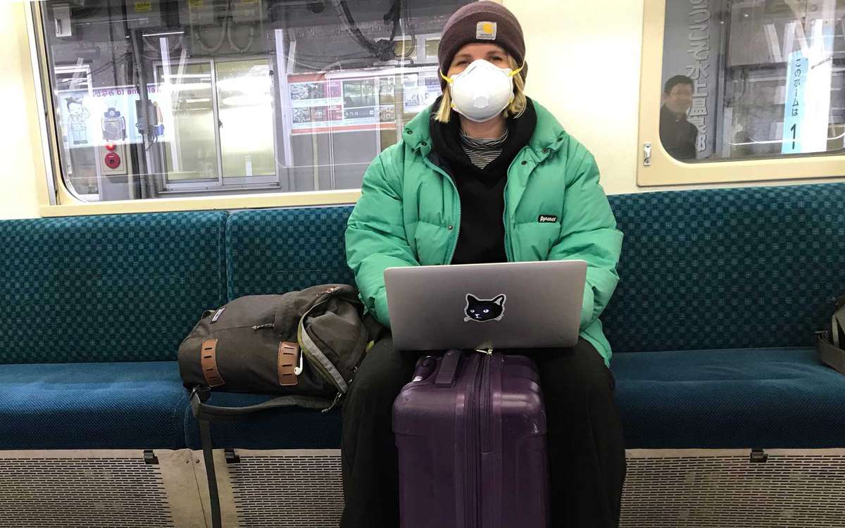 Writer, Eve Carrick, on the train in Tokyo with protective mask.