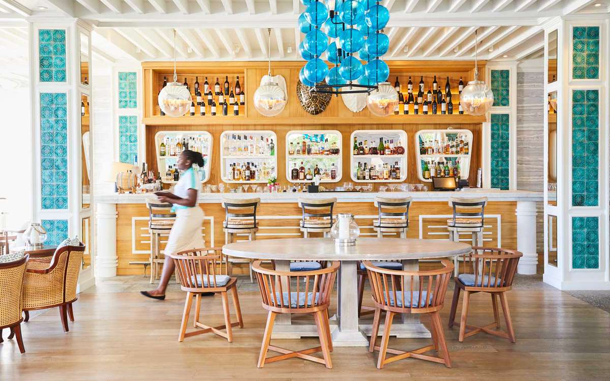 A waitress carrying drinks move through the Turtles bar at the Mandarin Oriental on the island of Canouan