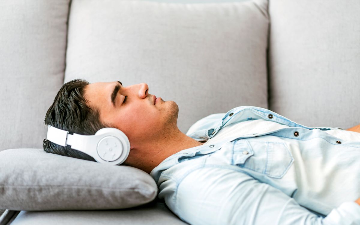 Man laying on couch listening to guided meditation