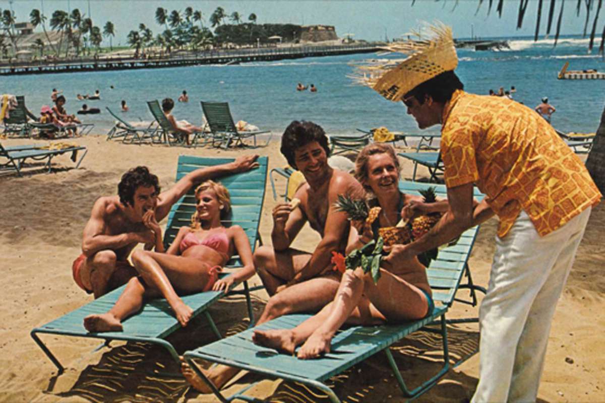 Vintage photo of guests of Caribe Hilton, Puerto Rico enjoying Piña coladas by the beach