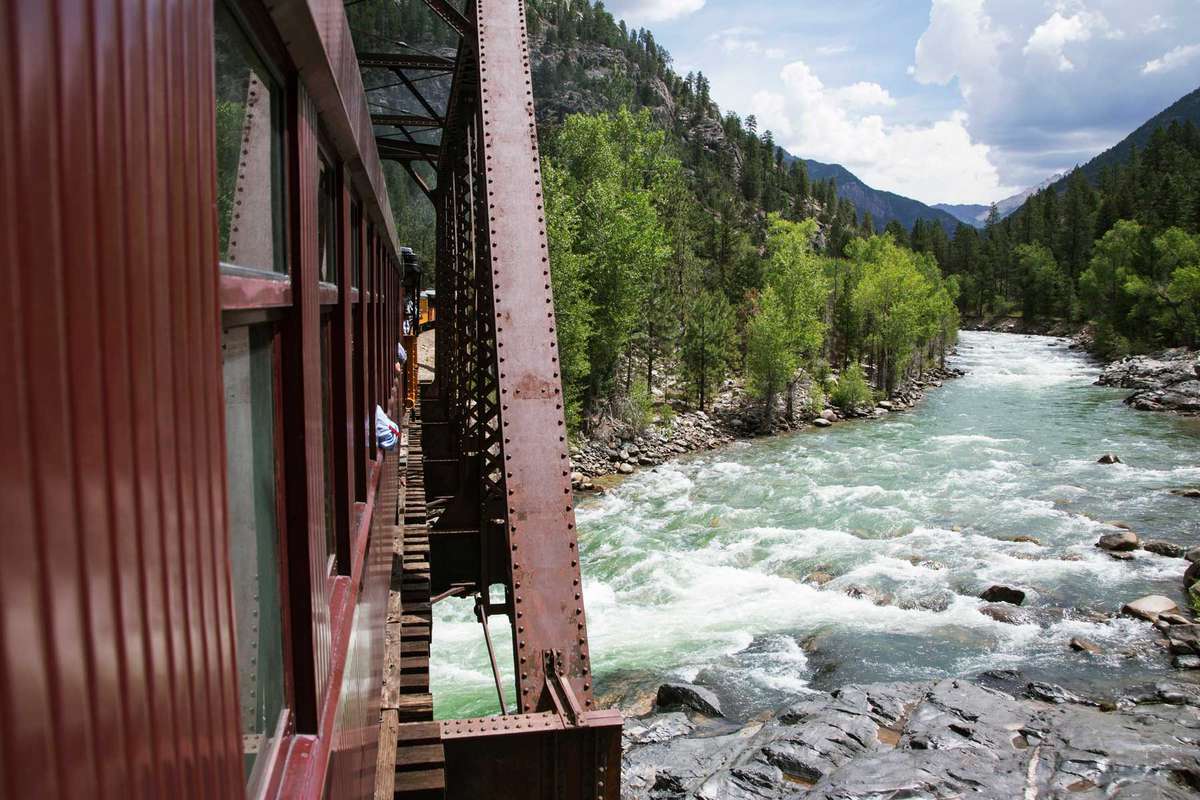 The Durango and Silverton Narrow Gauge Railroad Steam Engine travels along Animas River, Colorado