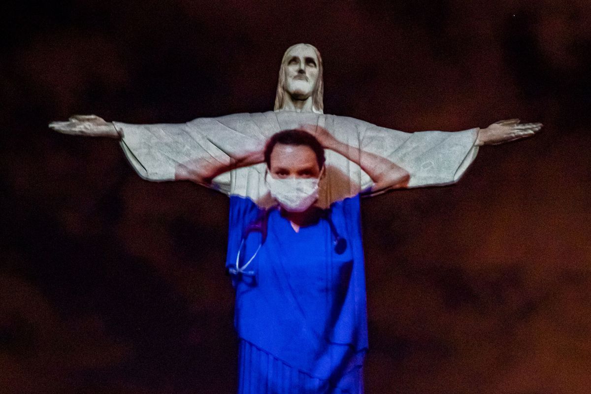 View of a medical worker on the illuminated statue of Christ the Redeemer