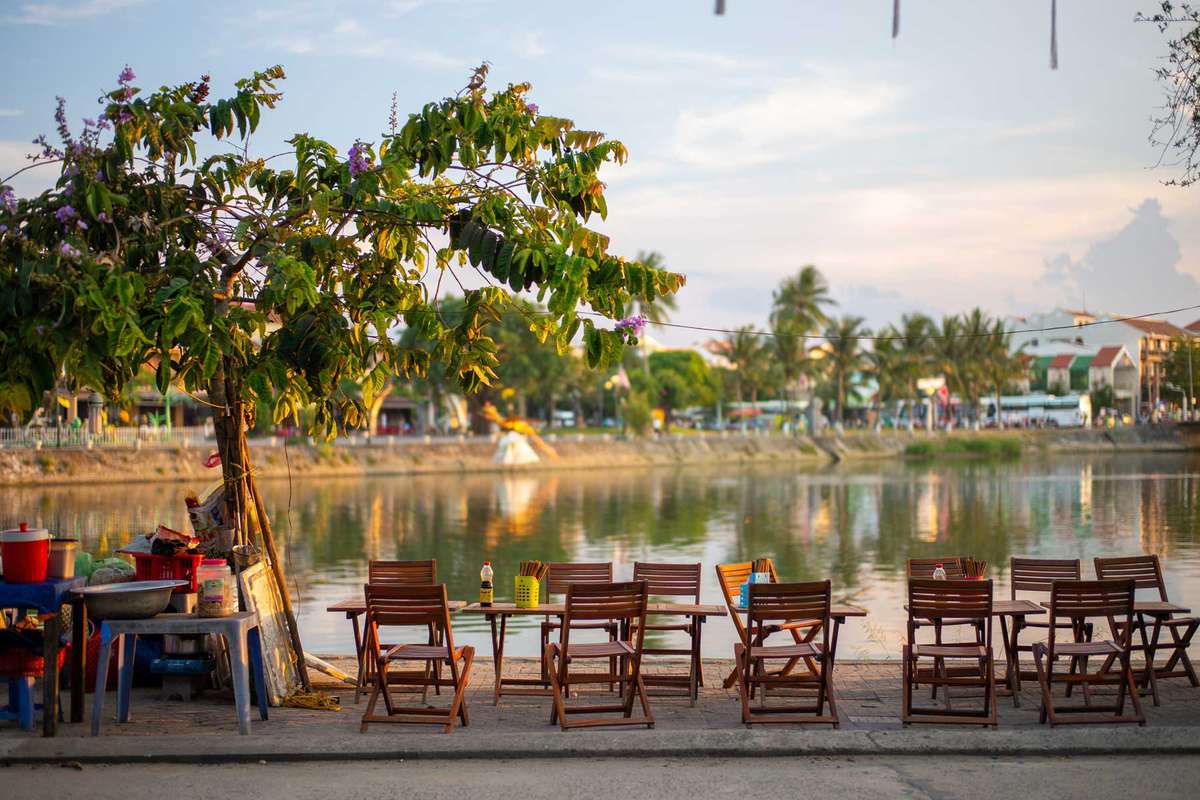 Food stall with chairs and tables by the riverside of Hoi An old town