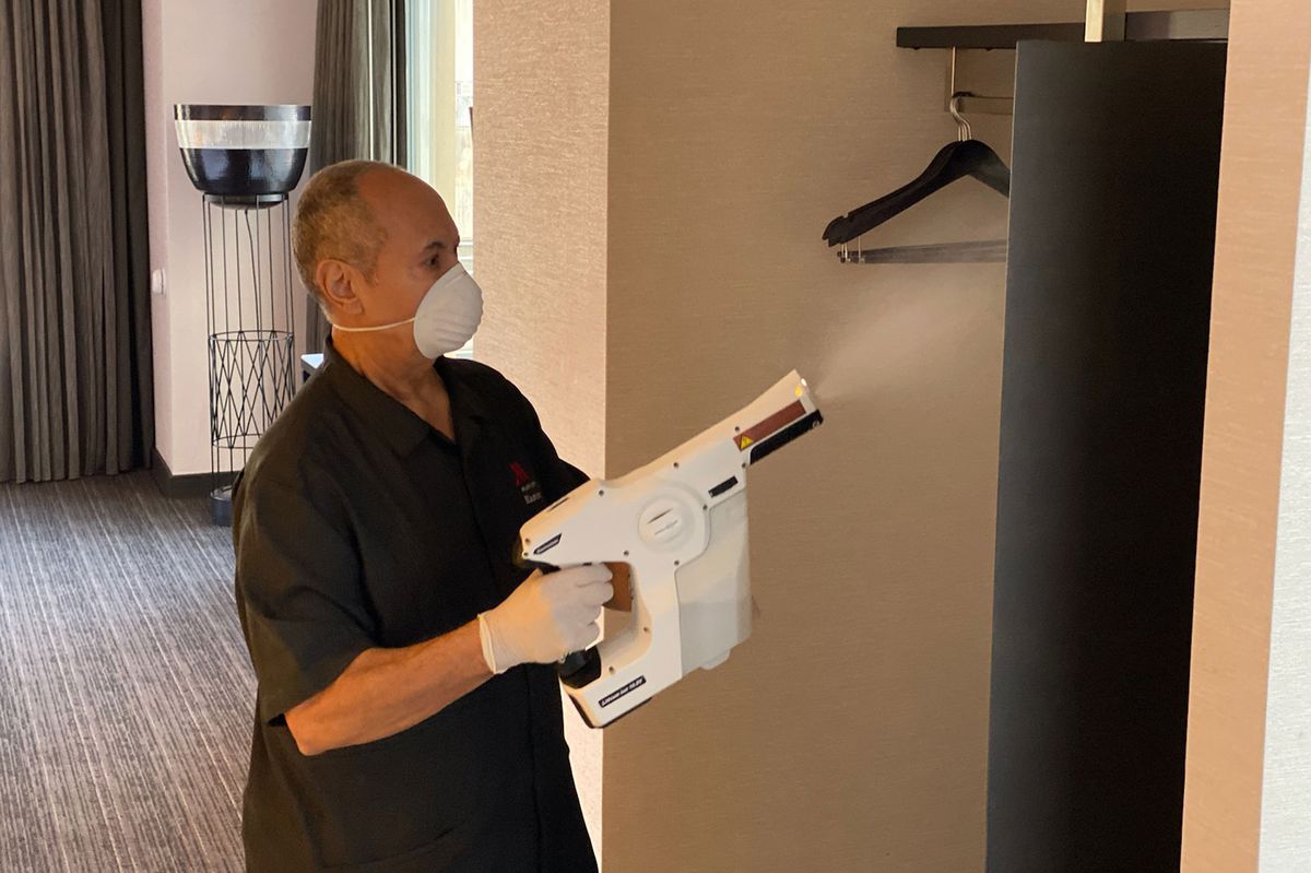 Marriott employee sanitizing hotel room