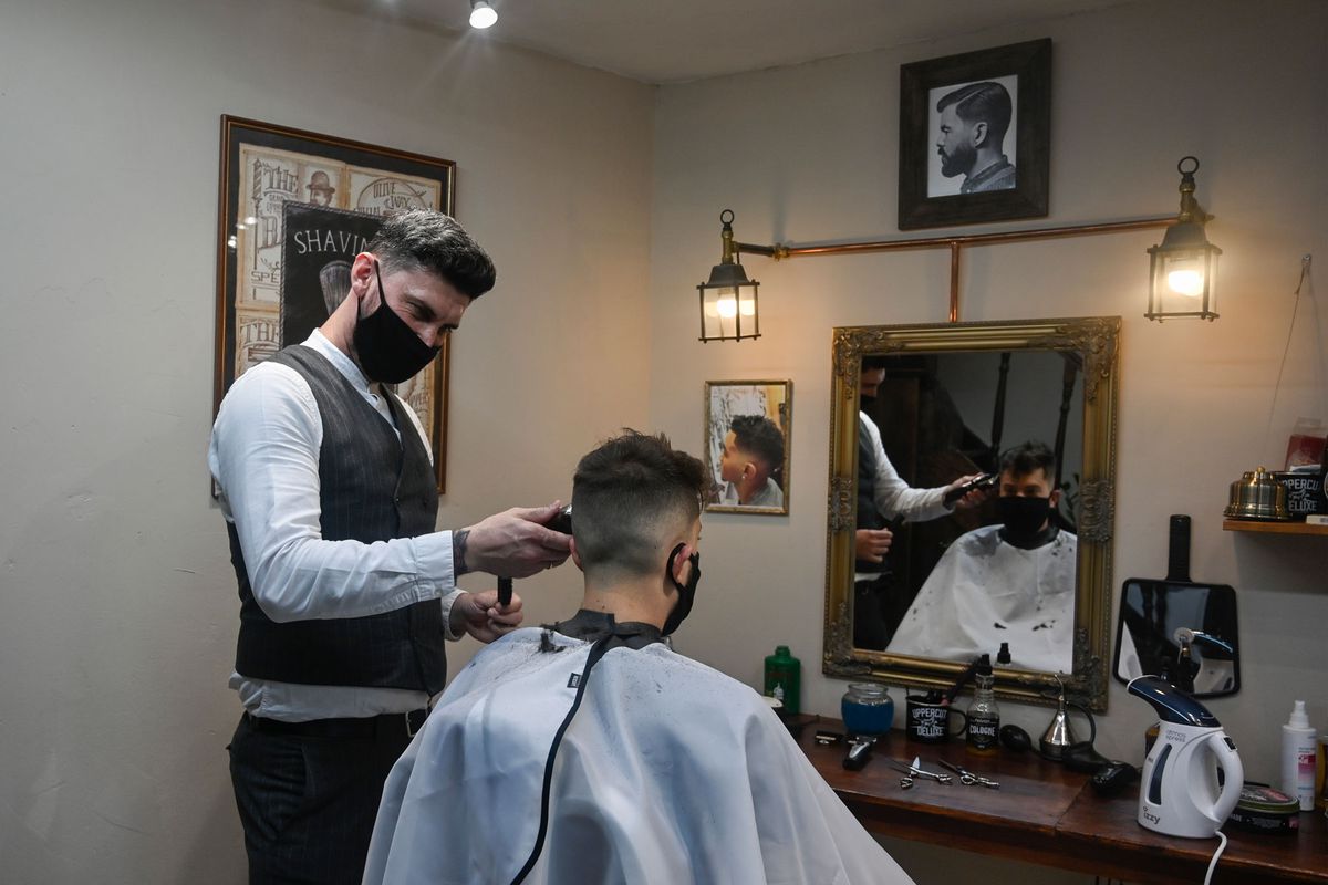 men in barber shop wearing face masks
