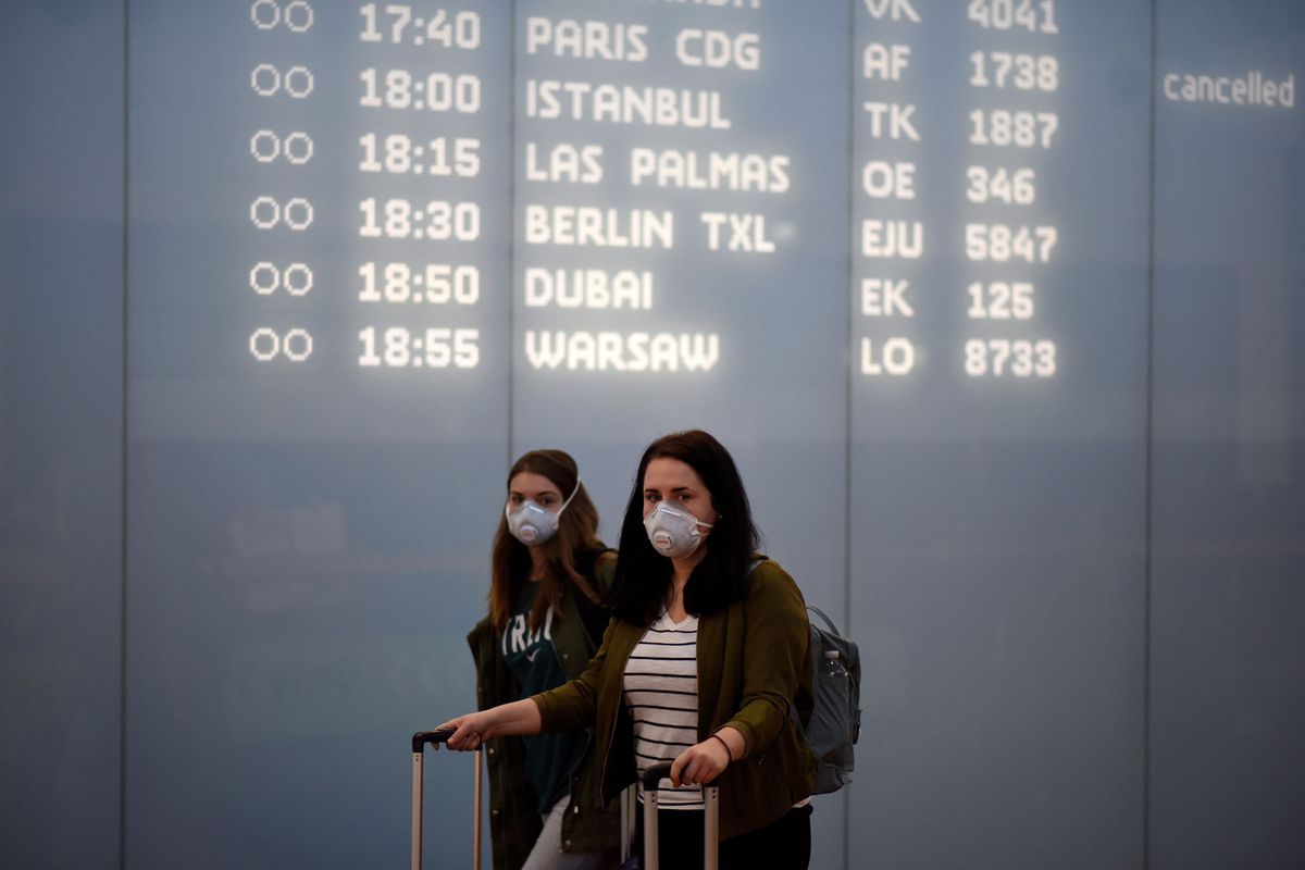 passengers with protective masks arrive at Vienna International Airport
