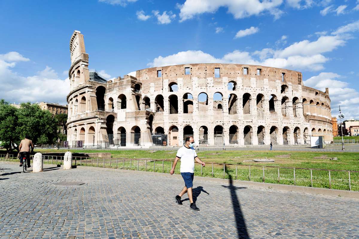 man runs outside the Colosseum in Rome