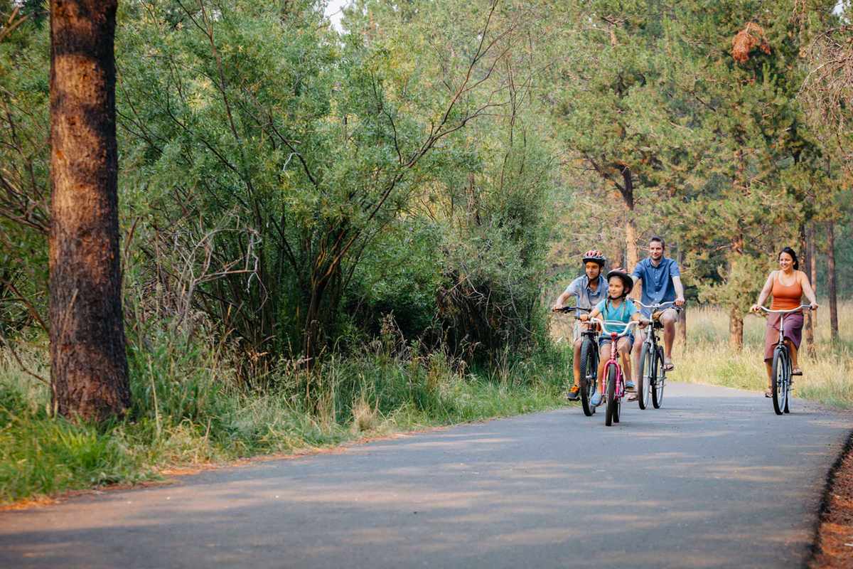 Guests ride bikes on a trail at Sunriver Resort in Oregon