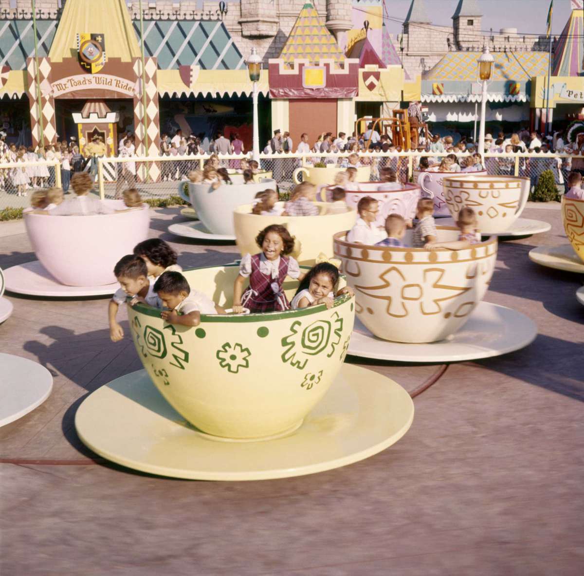 Cups and saucers filled with children at the 'Mad Hatter's Tea Party' attraction in Fantasyland, Disneyland Amusement Park, Anaheim, California.