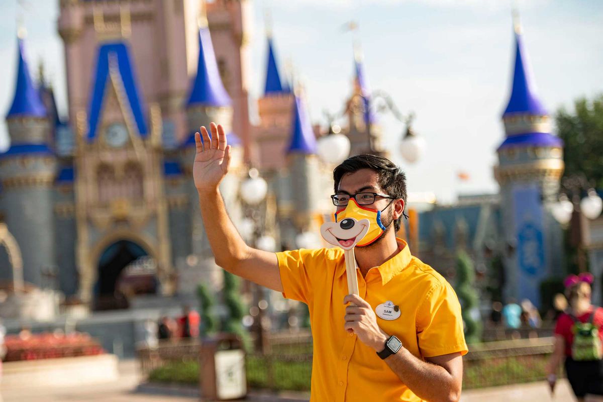 Disney cast member welcomes guests to Magic Kingdom Park at Walt Disney World Resort on July 11, 2020 in Lake Buena Vista, Florida.