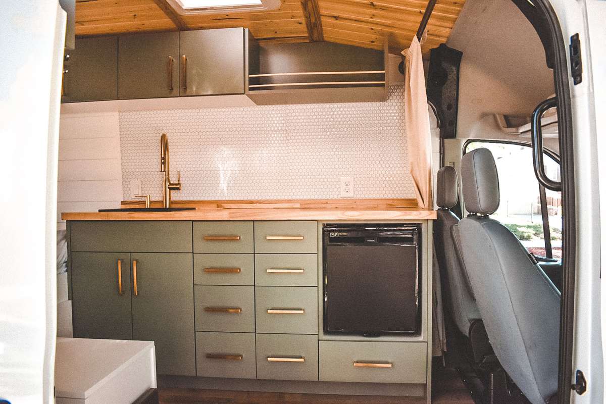 Camper van kitchen with green cabinets