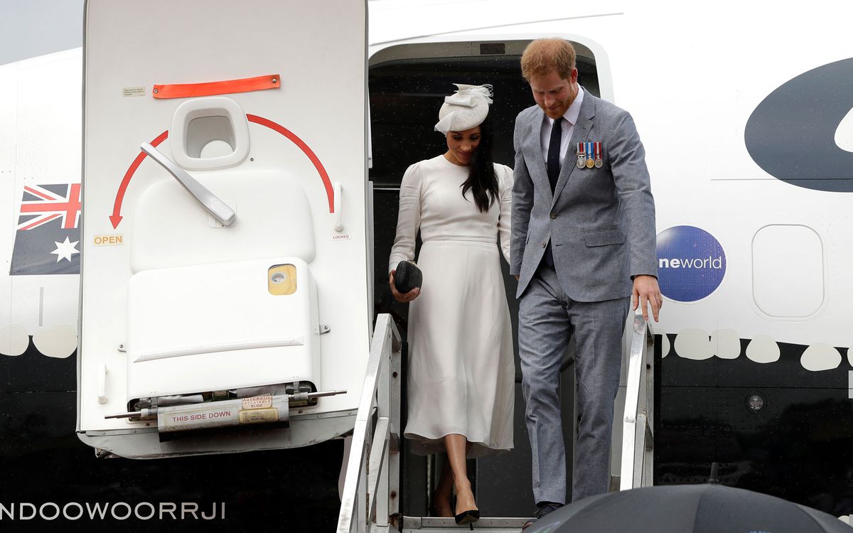 Meghan Markle and Prince Harry walking down stairs of airplane