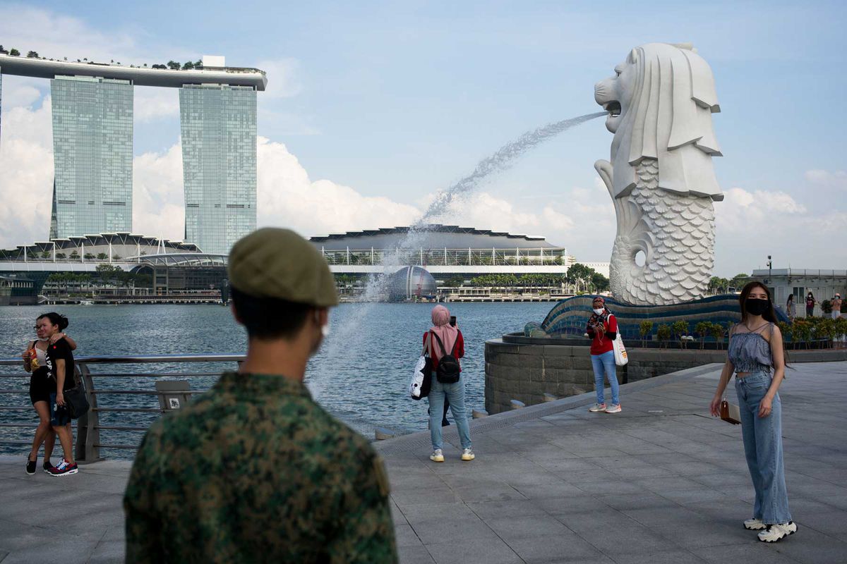 A soldier asks the public to exit the Merlion park due to the closure of the place for the Singapore National Day celebration